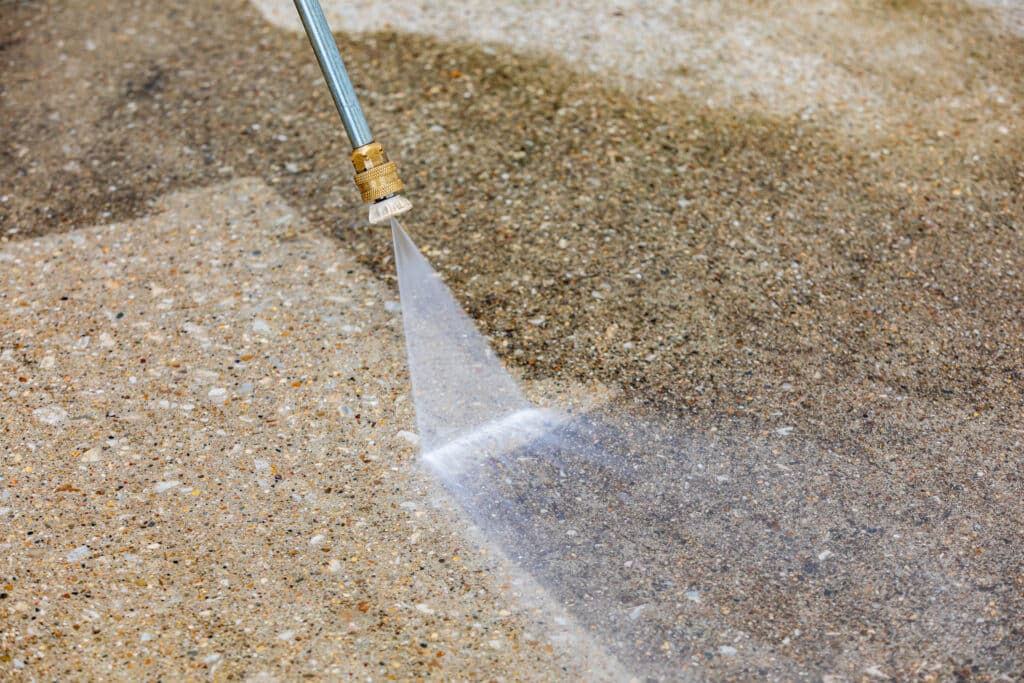 Pressure washing concrete driveway. Home cleaning, maintenance and household chores concept